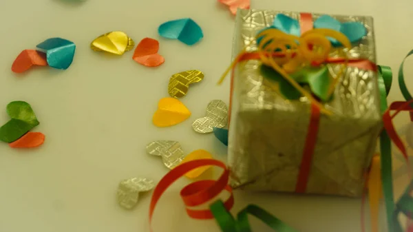 Küçük hediye kutuları renkli bokeh, işaret fişeği arka plan üzerinde renkli kalp şekil şerit.