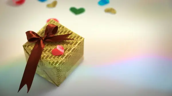 五颜六色的心脏形状丝带与小礼品盒在五颜六色的 Bokeh 耀斑背景 — 图库照片