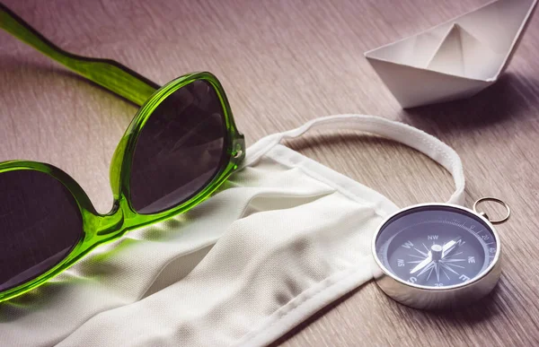 Safe Travel, mask and compass with green sunglasses