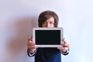 Okul çocuğu tablet uzanmış kollarını tutar. Bir okul çocuğu ellerinizde tablet.