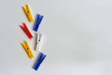 Beyaz bir arka plan üzerinde çok renkli clothespins dönüştürün. Komik renkli clothespins dönüştürün. Tasarımcı arka plan