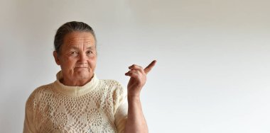 Beyaz bir arka plan üzerinde yaşlı bir kadın portresi. Yaşlı bir kadın parmağını tarafına işaret..