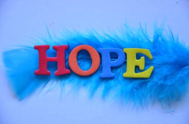 Mavi bir arka planda, umut dolu renkli bir kelime..