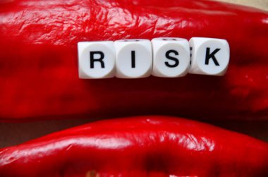 Siyah arkaplanda kelime riski ve kırmızı zar