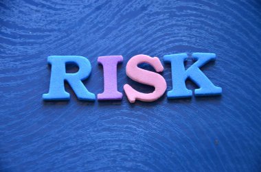 Mavi masadaki ahşap harflerden yapılmış kelime riski.