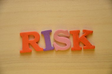 Renkli arka planda tahtadan küplere risk kelimesi