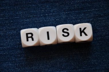 Koyu gri arka planda kelime şeklinde risk küpleri