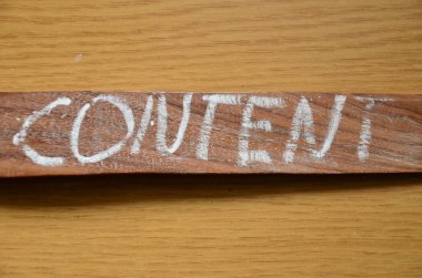 Yırtık tahtayla yazılmış bir kelime. ahşap bir arka planda.