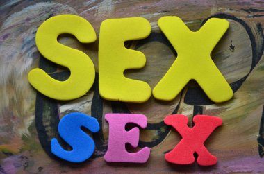 Tahta bir arka planda seks kelimesi.