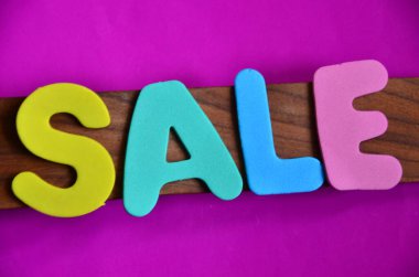 Siyah arka planda renkli ahşap harfler, satış..