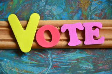 Oylama fikri. Ahşap arka planda renkli alfabe harfleri