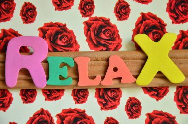 Rahatla ve rahatla. Pembe arka planda rahatlayan renkli harfler..