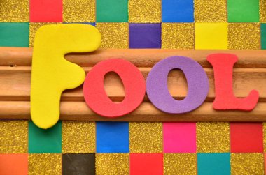 Tahta arka planda renkli harflerle sahte sözcük..