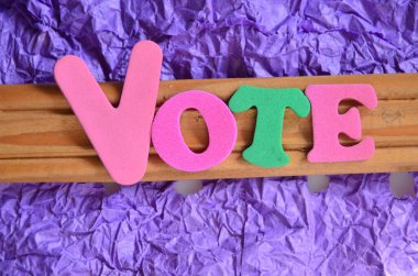 Ahşap arka planda renkli harflerle oy verin