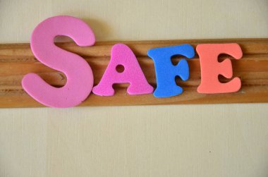 Güvenli - beyaz arkaplanda renkli ahşap harfler