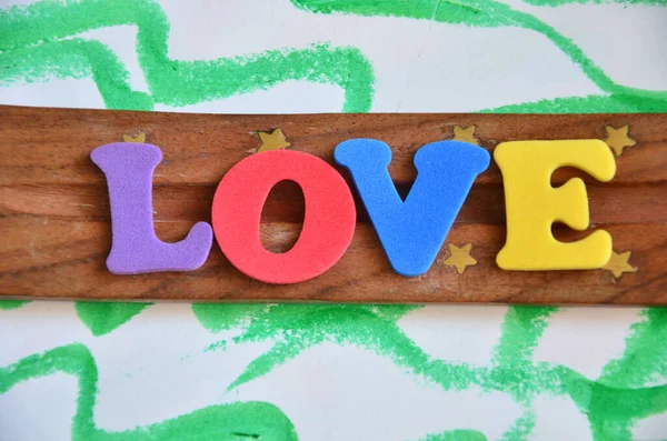 Ahşap arka planda renkli bir kelime.