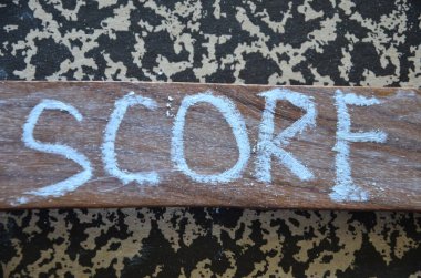 Üzerinde skor yazan bir tahta tabela.