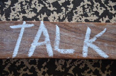 Karanlık bir arka planda ahşap harflerden oluşan kelime konuşması..