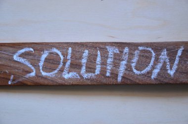 word solution written with white letters on wooden background