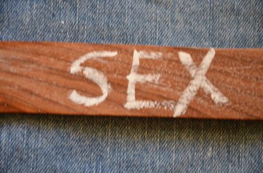 the word love in the shape of a wooden heart on a wooden board.