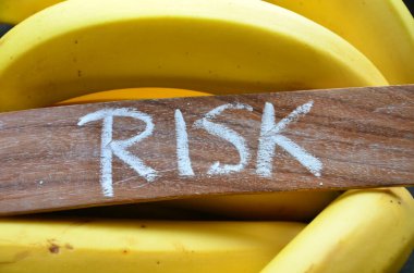 word risk on a wooden block on black background