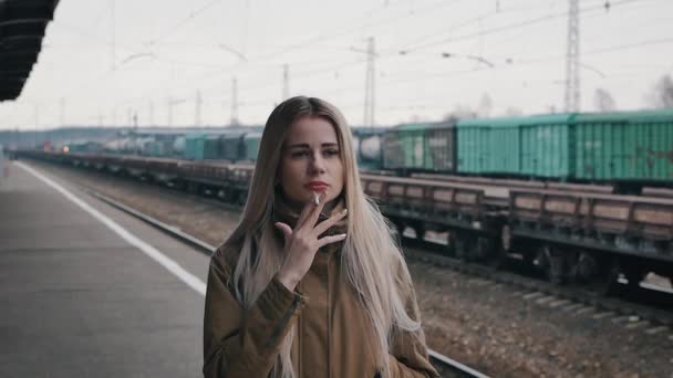Girl smokes at the station — Stock Video