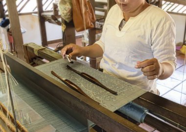 Kamboçya, Siem Reap Eyaleti, altın ipek Firma - Mart 2016: Doğal ipek tarım ve ipek eserler el işi üretimi-bayanlar handweaving antik desen üzerinde geleneksel dokuma ipek 