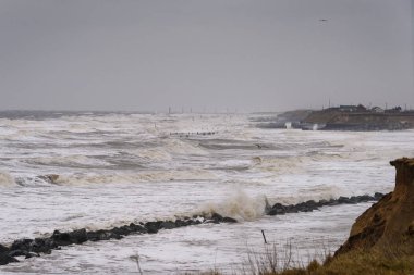 İngiltere'de, Happisburgh - 18 Mar 2018: kıyı erozyonu bir kar fırtınası sırasında yer alıyor. Bir çok evde son zamanlarda kıyı şeridi yiyip deniz nedeniyle bu toplumda kaybolmuş.