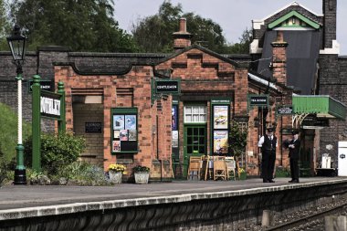Rothley büyük Merkezi Buhar demiryolu, İngiltere - 2015: A istasyon şefine ve meslektaşı stand ve bir vintage tren istasyonu kapalı bir kafede dışında platformda konuşmak