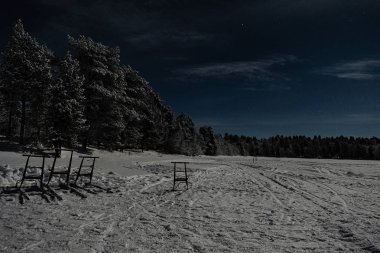 Mavi sk üzerinde orman ve göl ile Lappish moonlit kış manzara