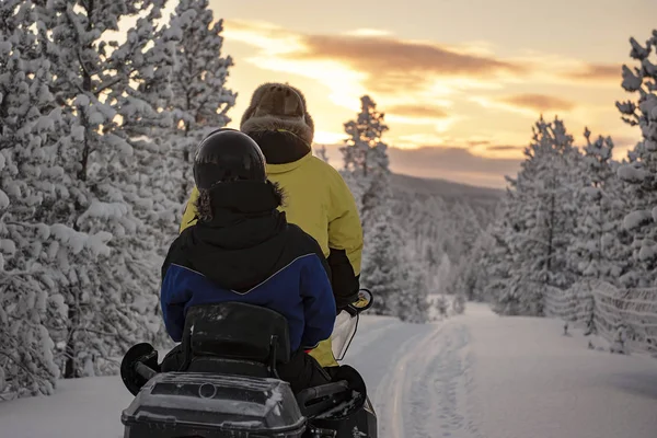 2 pessoas montando em uma moto de neve através dos bosques da Lapônia — Fotografia de Stock