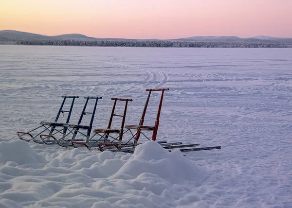 Gruppe von Schlittensitzen auf zugefrorenem See — Stockfoto
