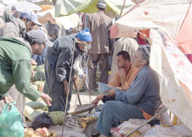 Bir çiftçi onun üretimi satmak için bekliyoruz oturur