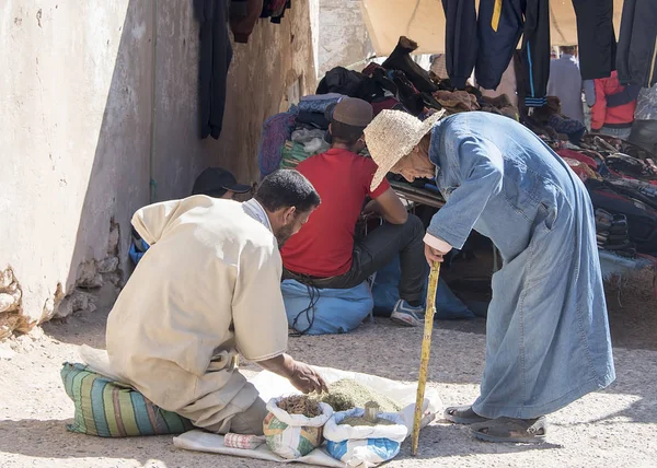 Berberi marketi 'nde bükülmüş yaşlı bir adam alışverişi