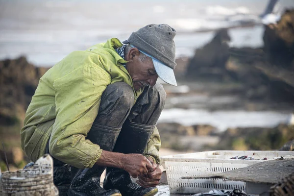 Pescador preparando isca no início da manhã — Fotografia de Stock