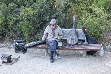 Parkta Busker günün sonunda kazançlarını sayma