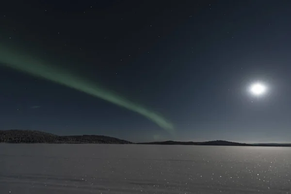 Grüne Nordlichter streifen über einen Himmel, der von einem Supermond erleuchtet wird — Stockfoto