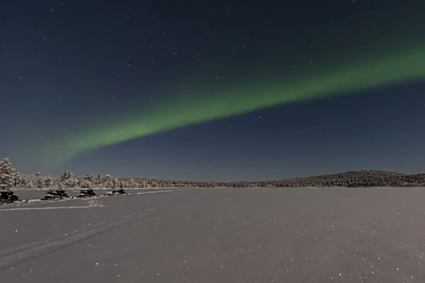 Ooking across a frozen lake to the northern lights — Stock Photo, Image