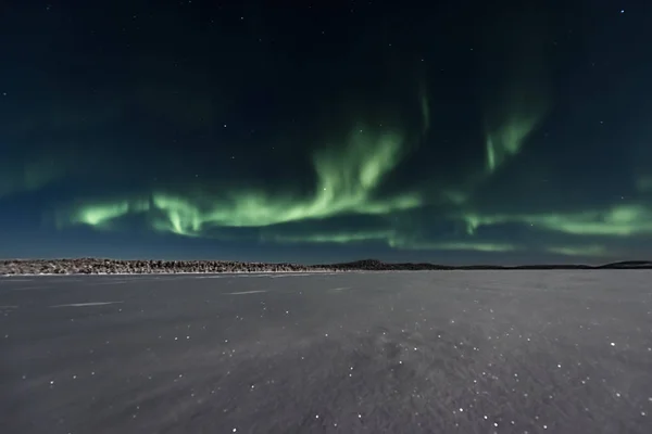 Cooking across a frozen lake to the northern lights — стоковое фото