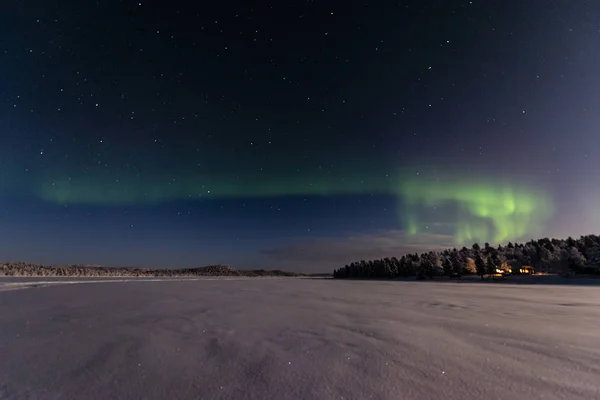 Okatování přes zamrzlé jezero na severní světla — Stock fotografie