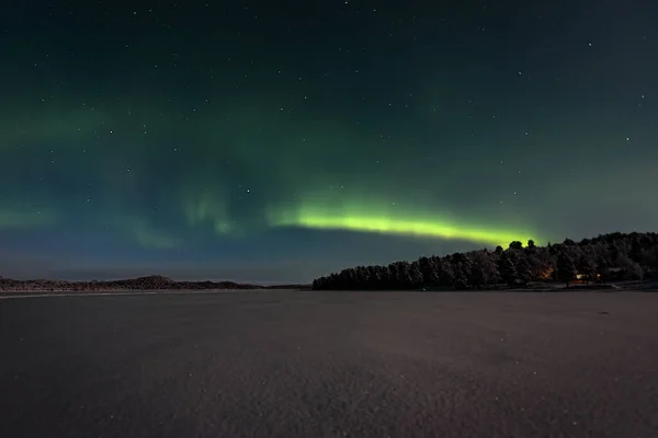 Cooking across a frozen lake to the northern lights — стоковое фото