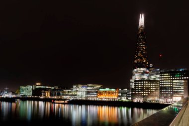 Londra, İngiltere - Ocak 2020: Londra, İngiltere - Ocak 2020: The Shard, London Bridge Hospital, City Hall ve güney kıyısındaki diğer binalar Thames Nehri 'ni aydınlattı ve yansıttı. Uzun pozlama.