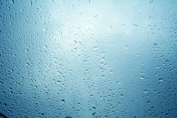 Tetes air di latar belakang biru / tetesan hujan di kaca, hujan d — Stok Foto
