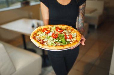 Lezzetli bir pizza ile iki farklı tabak taşıma garson. Fotoğraf iki pizza ile. Mantar ve salamlı pizza pizza.