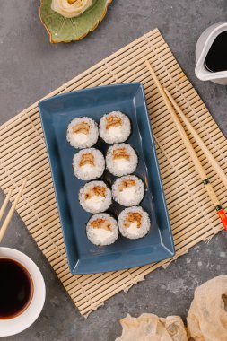 Bir Japon restoranında yemek. Seçici odak yakın kadar ton balığı bir ışık gri tabloda gri dikdörtgen plaka üzerinde siyah bir dikdörtgen plaka üzerinde rulo