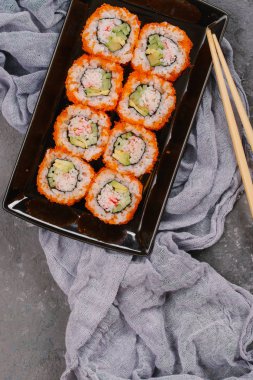Güzel Philadelphia suşi Roll kümesiyle somon, yumuşak peynir ve ahşap rustik arka plan üstten görünüm krem şanti. Uramaki, Nori Maki veya Futomaki suşi alabalık filetosu, soya sosu ve Wasabi ile