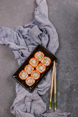 Güzel Philadelphia suşi Roll kümesiyle somon, yumuşak peynir ve ahşap rustik arka plan üstten görünüm krem şanti. Uramaki, Nori Maki veya Futomaki suşi alabalık filetosu, soya sosu ve Wasabi ile