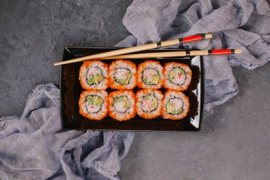 Güzel Philadelphia suşi Roll kümesiyle somon, yumuşak peynir ve ahşap rustik arka plan üstten görünüm krem şanti. Uramaki, Nori Maki veya Futomaki suşi alabalık filetosu, soya sosu ve Wasabi ile