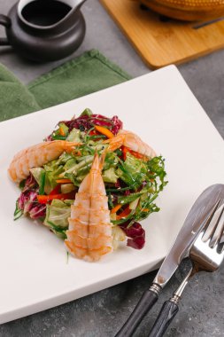 Tay yeşil beyaz tabak, sebze ve gri bir tablo lahanası salatası