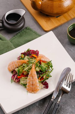 Tay yeşil beyaz tabak, sebze ve gri bir tablo lahanası salatası